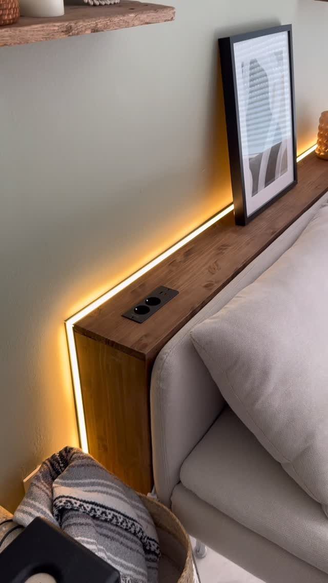 Wooden console table behind a sofa with integrated power outlets and LED lighting.