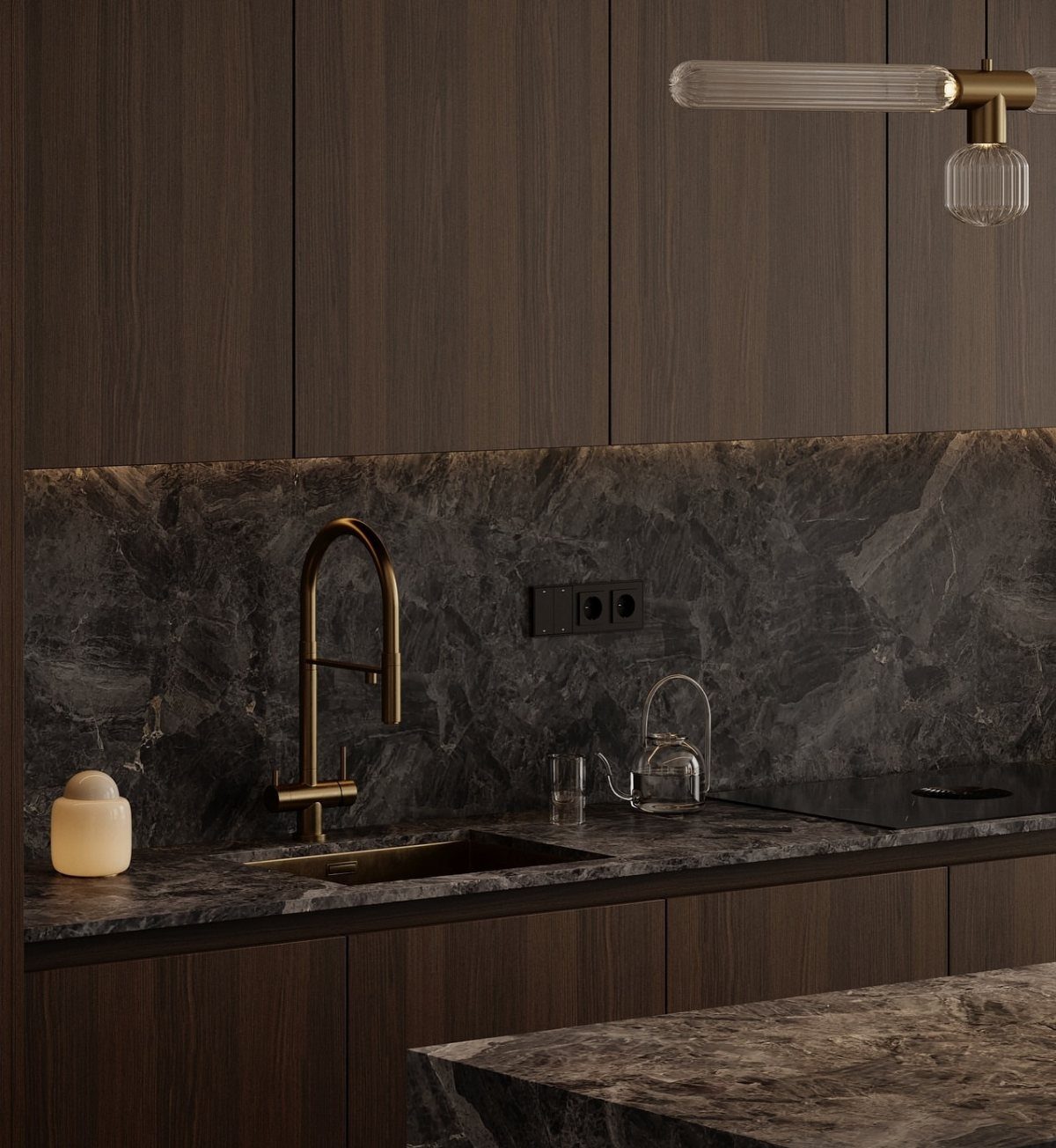 Dark wood kitchen cabinets with black marble countertops and a gold faucet.