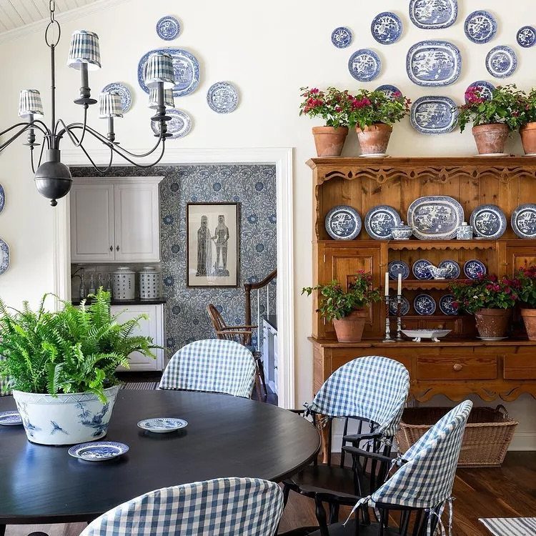 Country dining room with blue checkered chairs, wooden hutch, and blue and white pottery.