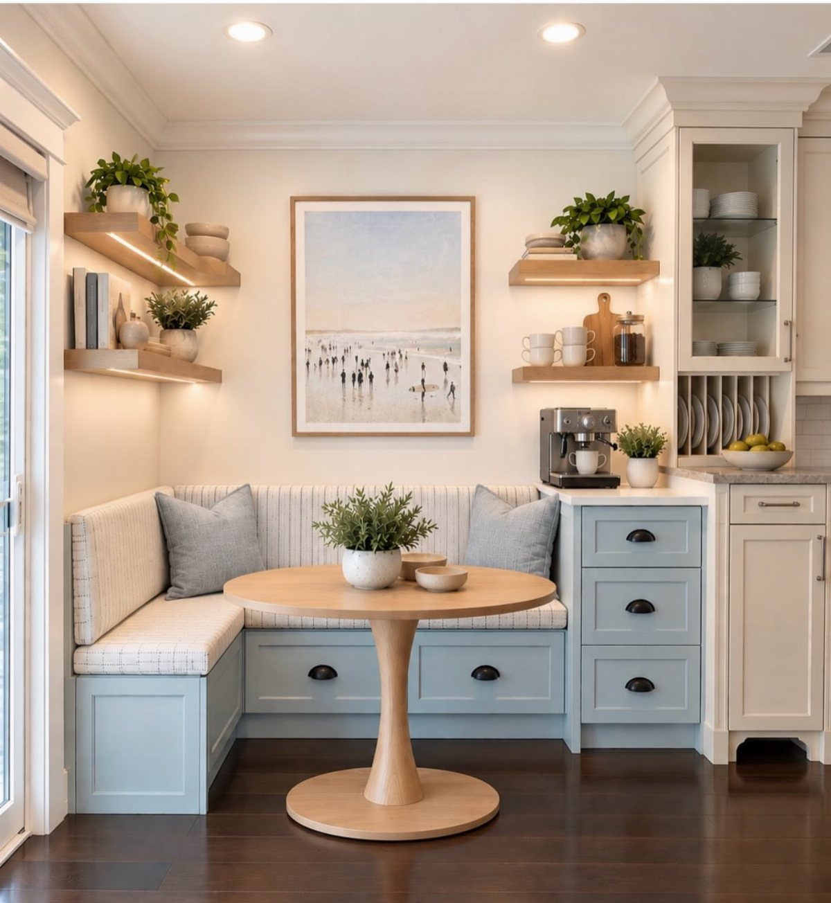 Light blue built-in L-shaped dining bench with a round wooden pedestal table.