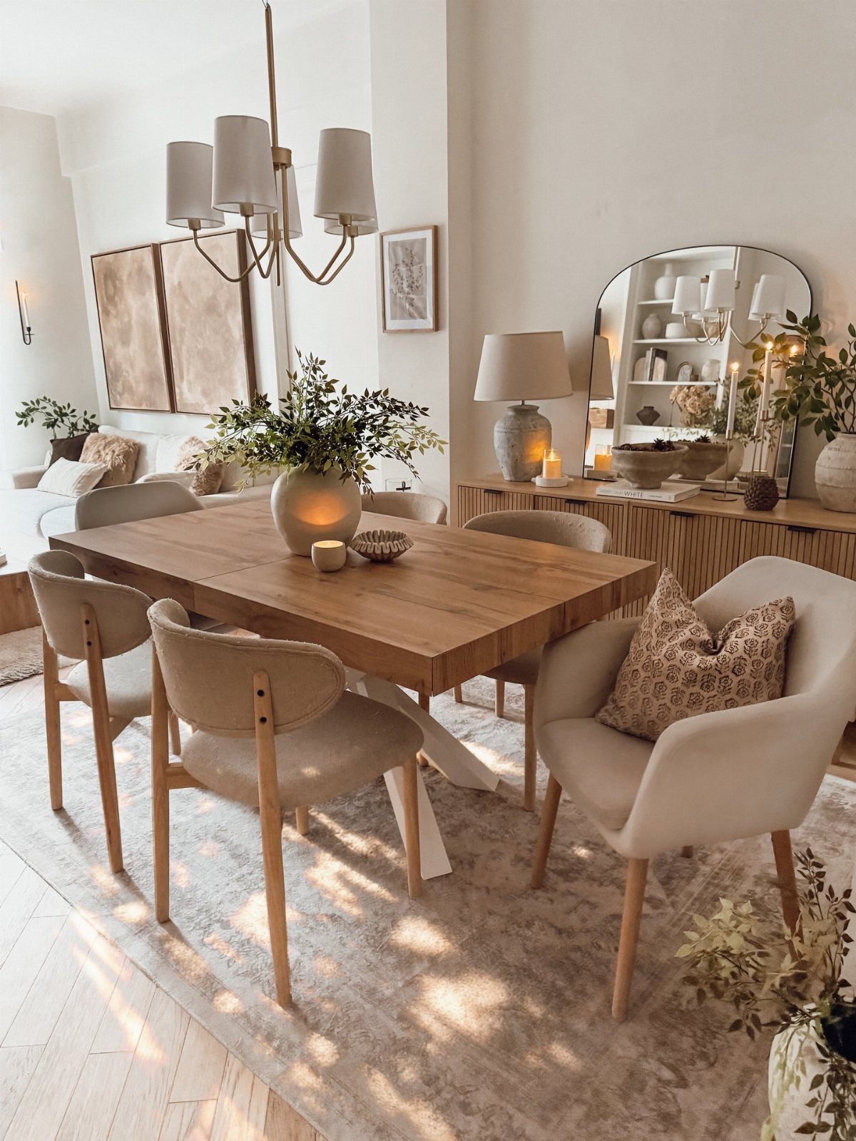 Wooden dining table and beige chairs on a light-colored textured area rug.
