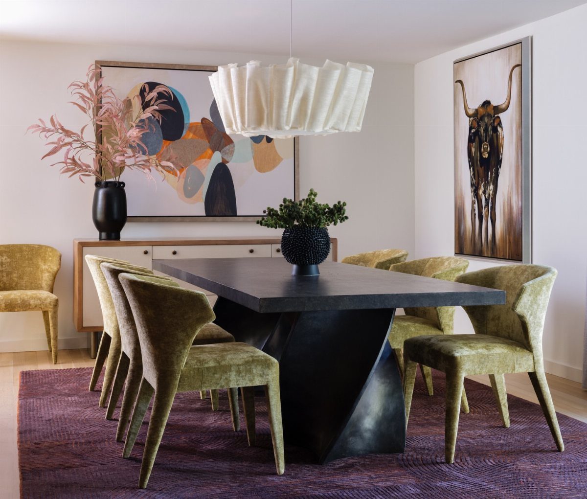 Dark sculptural dining table with olive green chairs on a purple textured rug.
