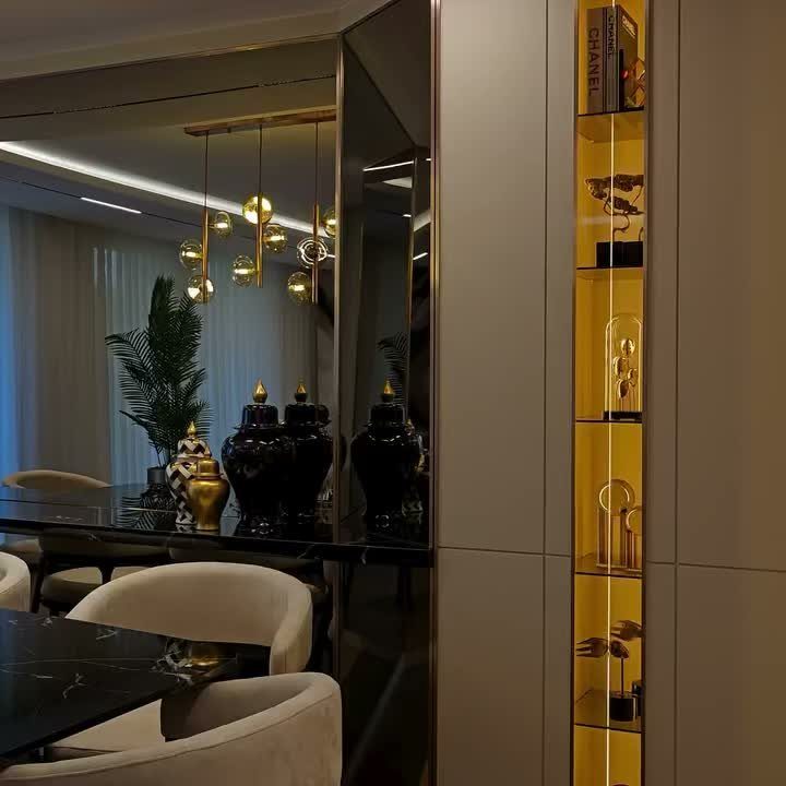 Black marble countertop with gold vases and a gold-lined recessed wall display shelf.