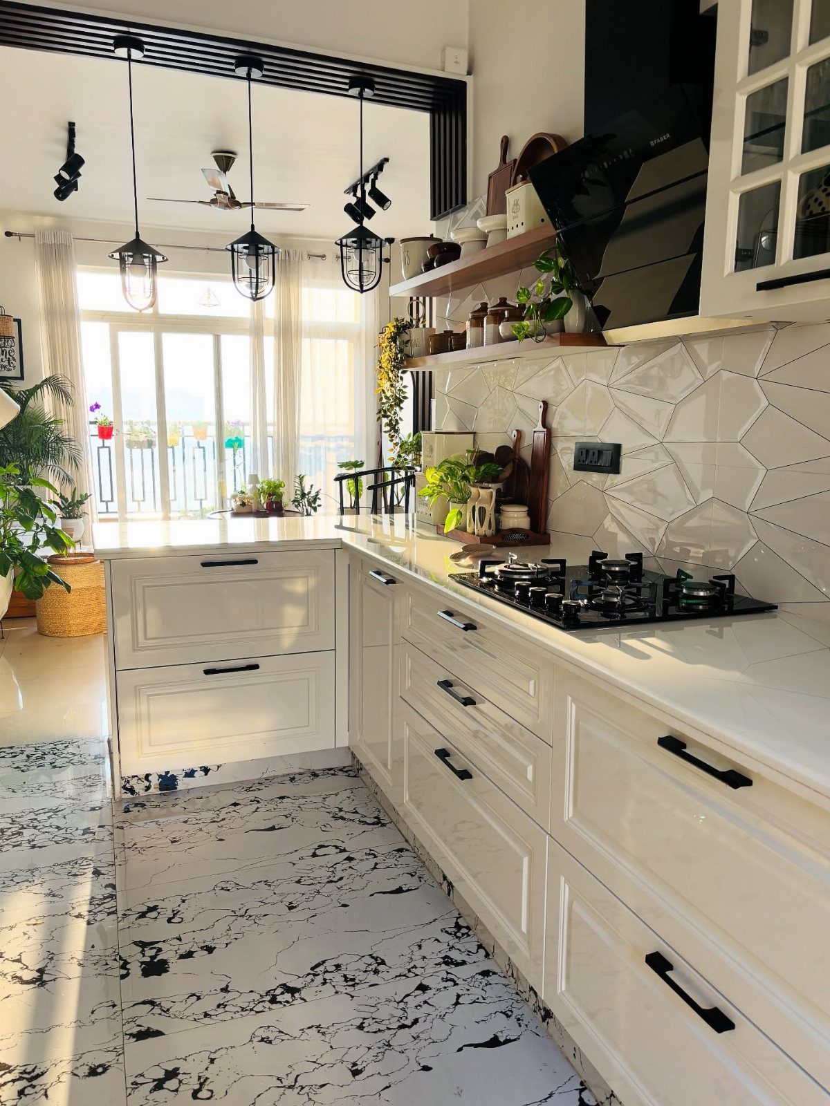 White kitchen with geometric tiles and several green potted plants on counters and shelves.