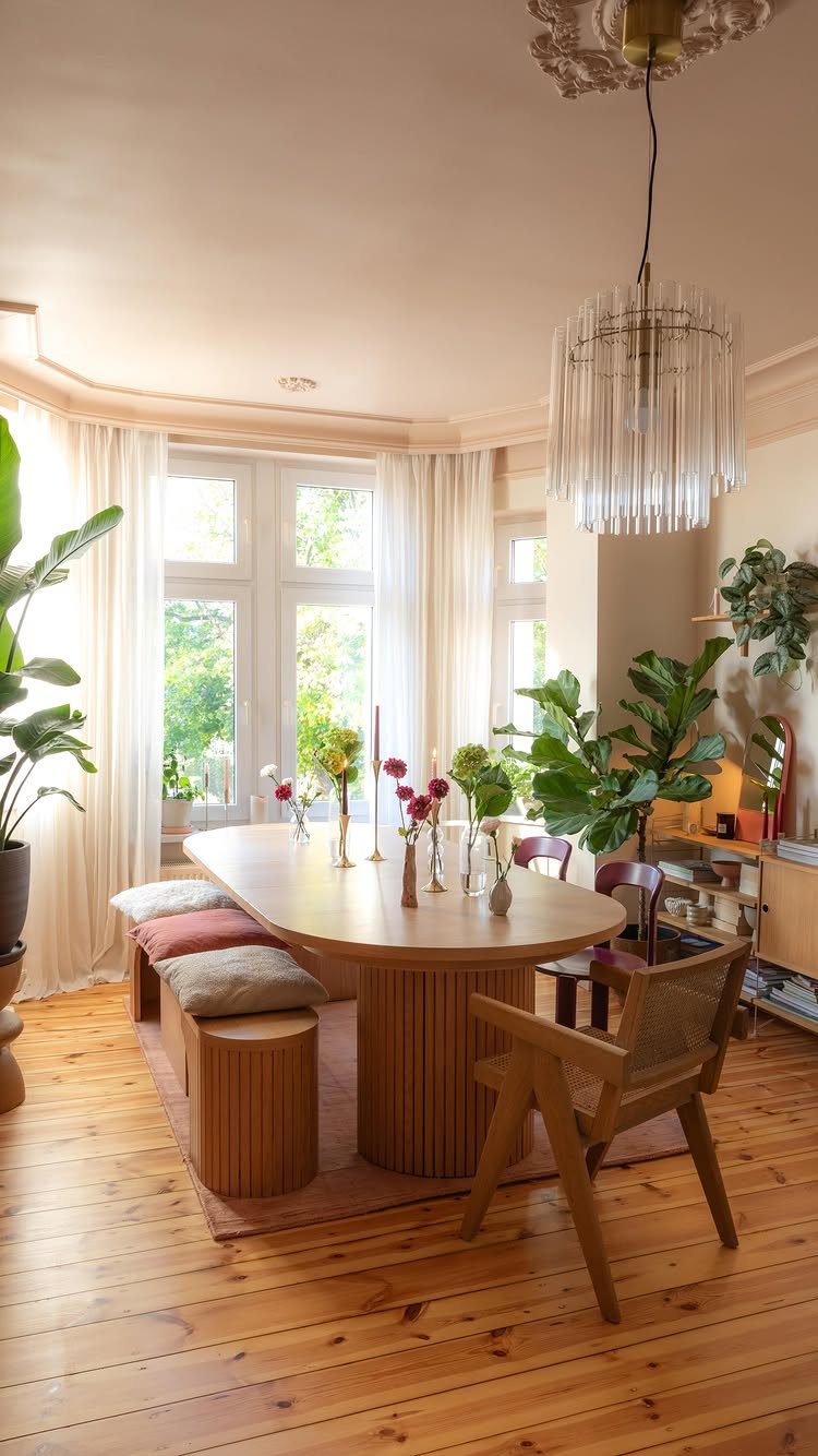 Dining nook with a fluted wooden table and banquette seating by a bay window