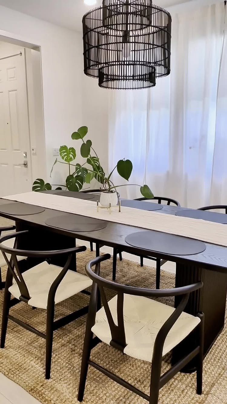 Dining room with a dark wood table and chairs on a textured tan rug.