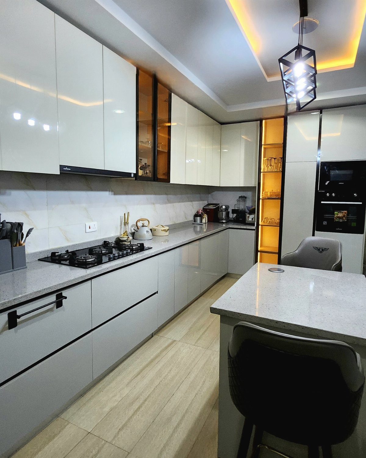 Modern kitchen with white upper cabinets and light gray lower cabinets and countertops.