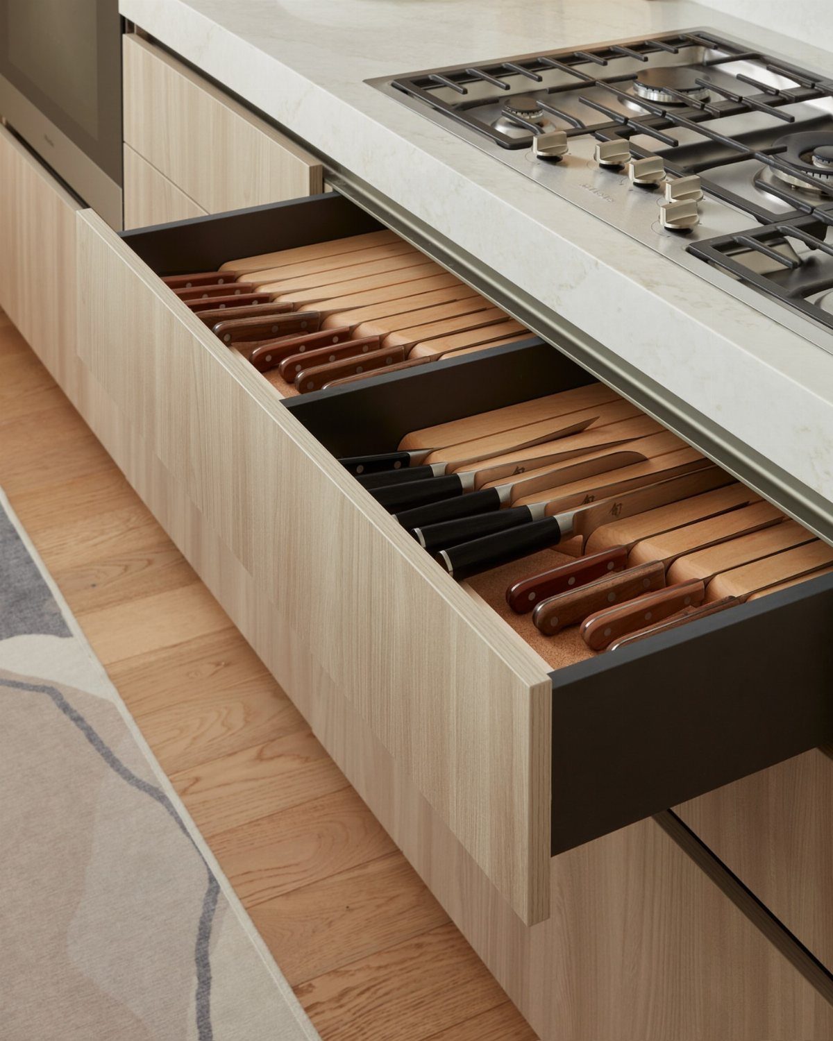 Open kitchen drawers featuring a wooden in-drawer knife storage block with various knives.