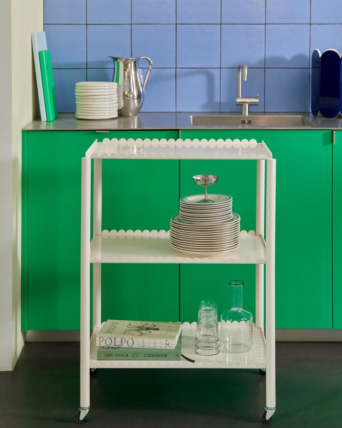 White Hay Arcs trolley with plates and glassware in a colorful kitchen.