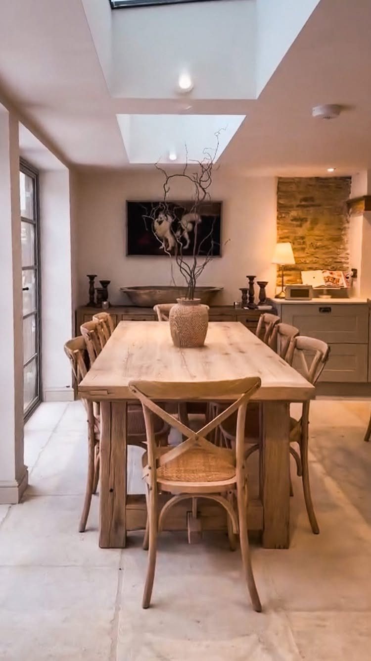 Wooden farmhouse table with cross-back chairs in a bright, neutral dining area.