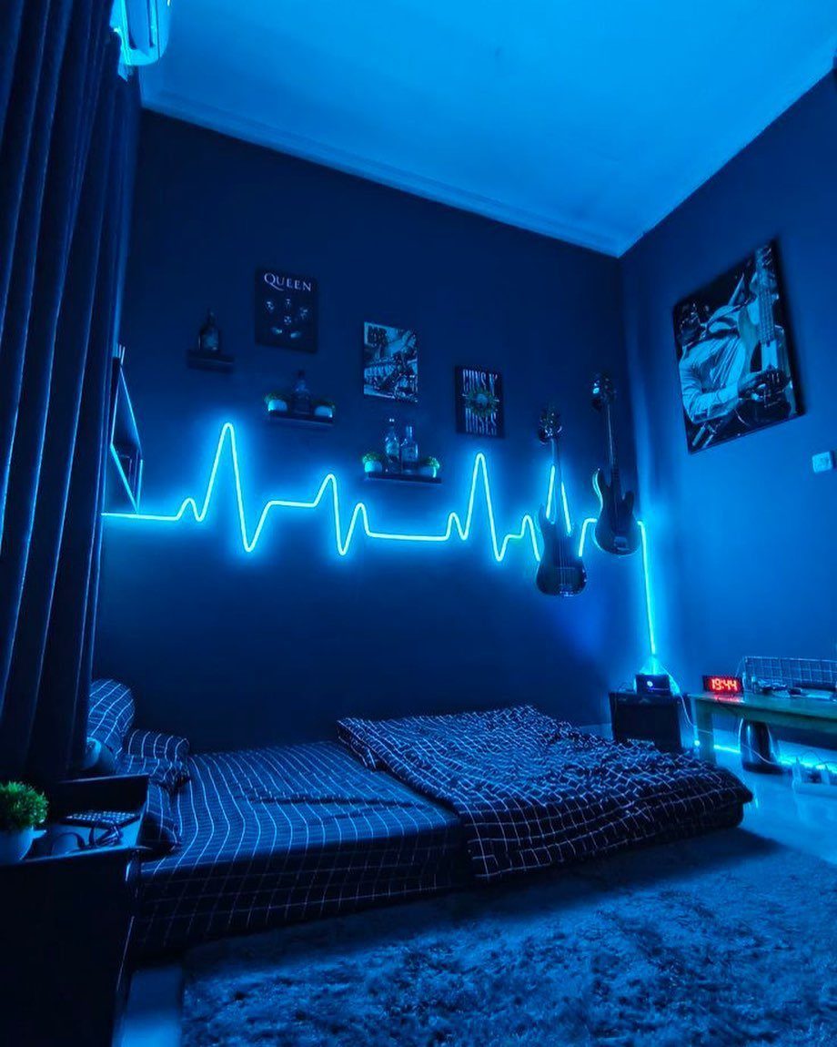 Navy blue curtains in a bedroom with dark blue walls and neon lighting.