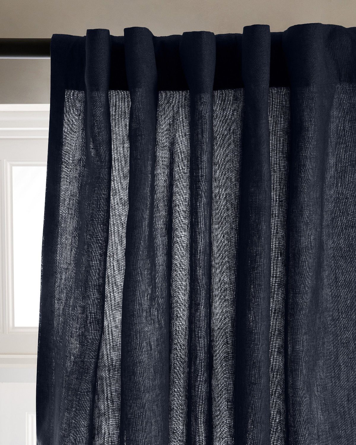 Navy blue linen curtains with a textured weave hanging from a black rod.