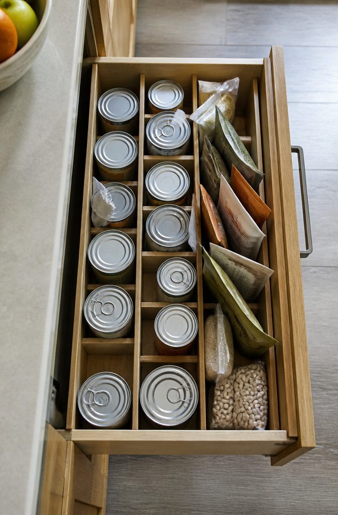 Deep kitchen drawer with upright tins and packets between dividers