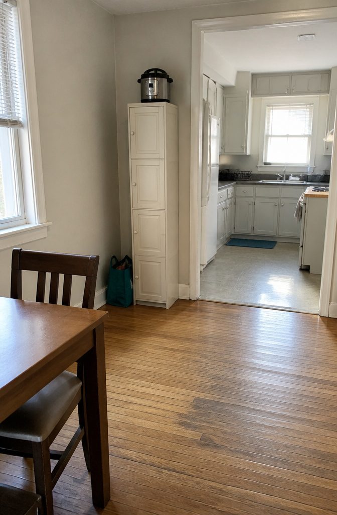 Tall freestanding pantry cabinet with closed doors in a small kitchen