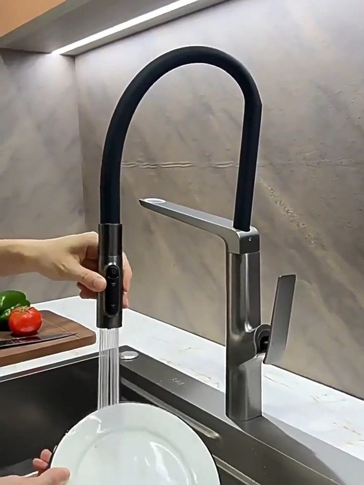 High-arc kitchen faucet with black flexible neck rinsing a white plate in sink