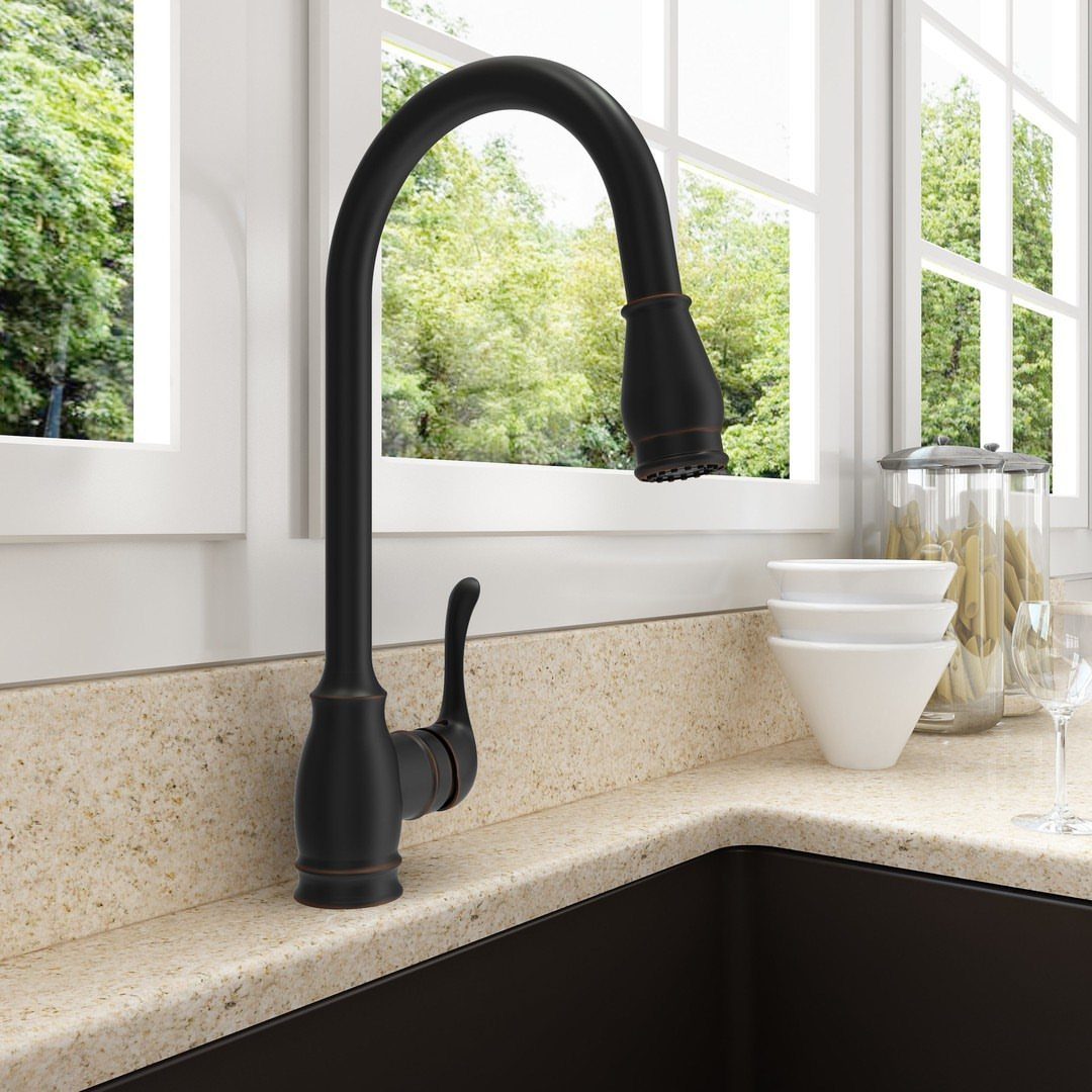 Matte black high-arc pull-down kitchen faucet on a beige speckled countertop.
