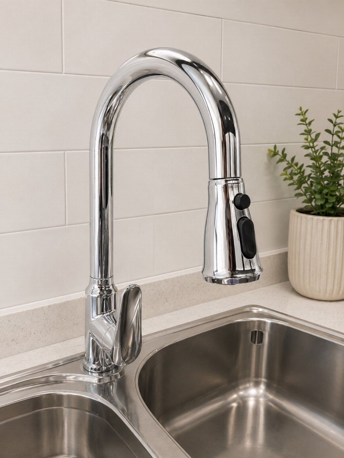 Chrome pull down kitchen faucet installed on a stainless steel double basin sink