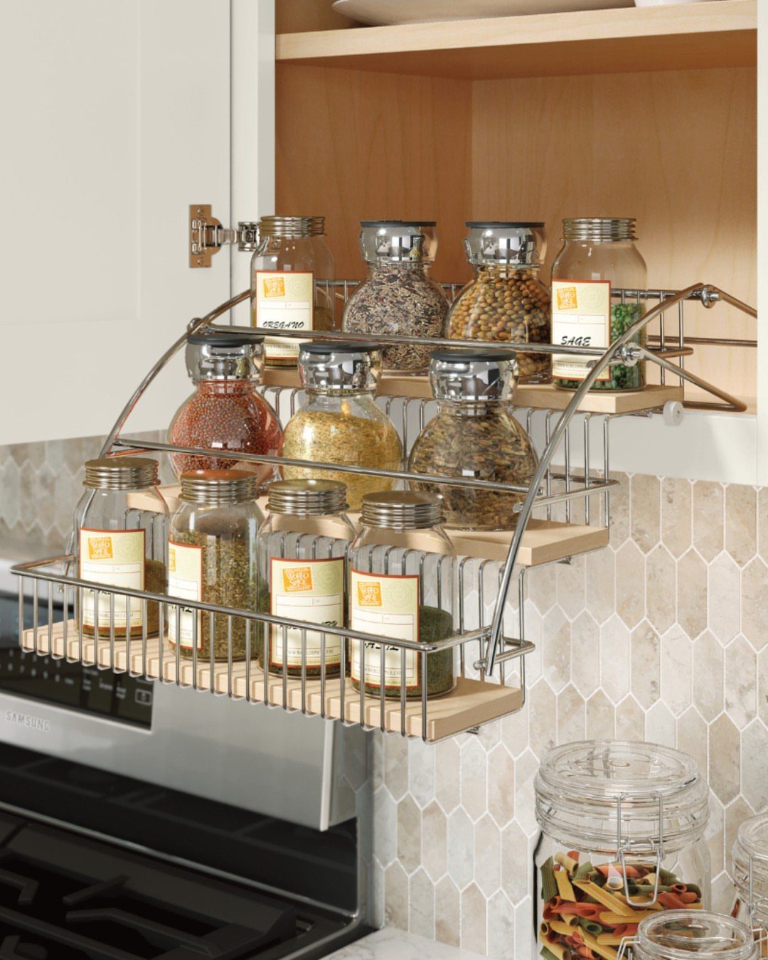 Pull-down spice rack with glass jars extended from a kitchen cabinet above a stove.
