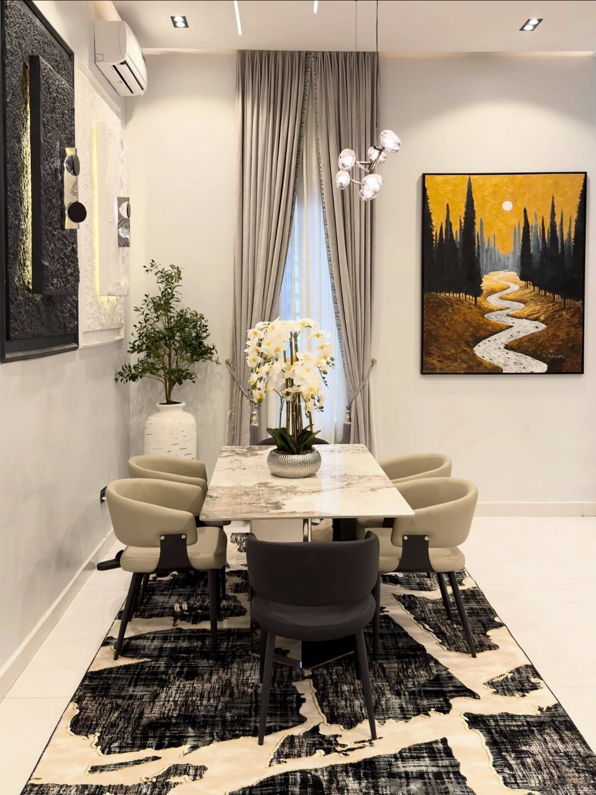 Marble dining table and chairs on a bold black and white patterned area rug.