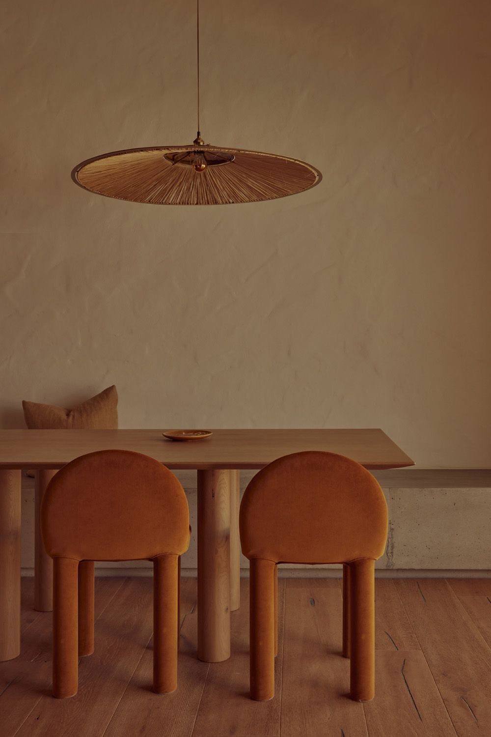 Tan velvet dining chairs with fully upholstered legs at a wooden table