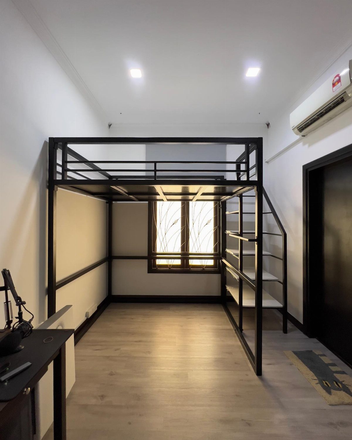 Charcoal grey metal loft bed frame in a modern white bedroom with wood floors.