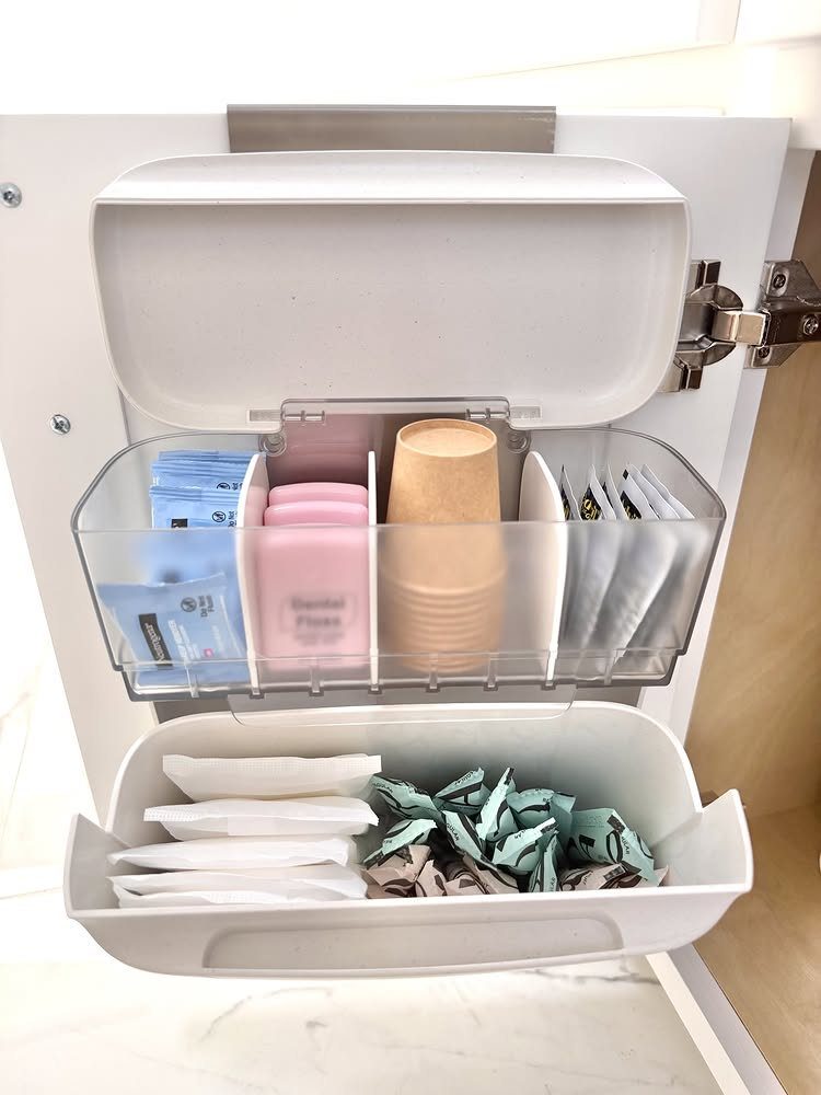White cabinet door with plastic organizers holding toiletries and small household items.