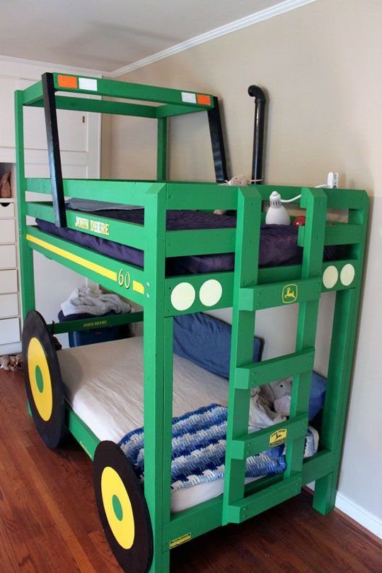 Green tractor-shaped bunk bed with large wheels and a ladder in a bedroom.