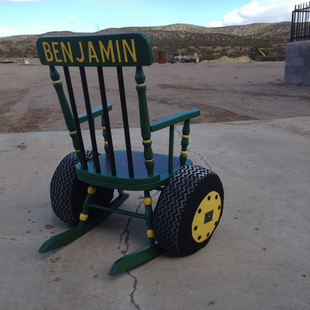 Tractor-themed rocking chair with green paint, yellow accents, and large tire wheels.