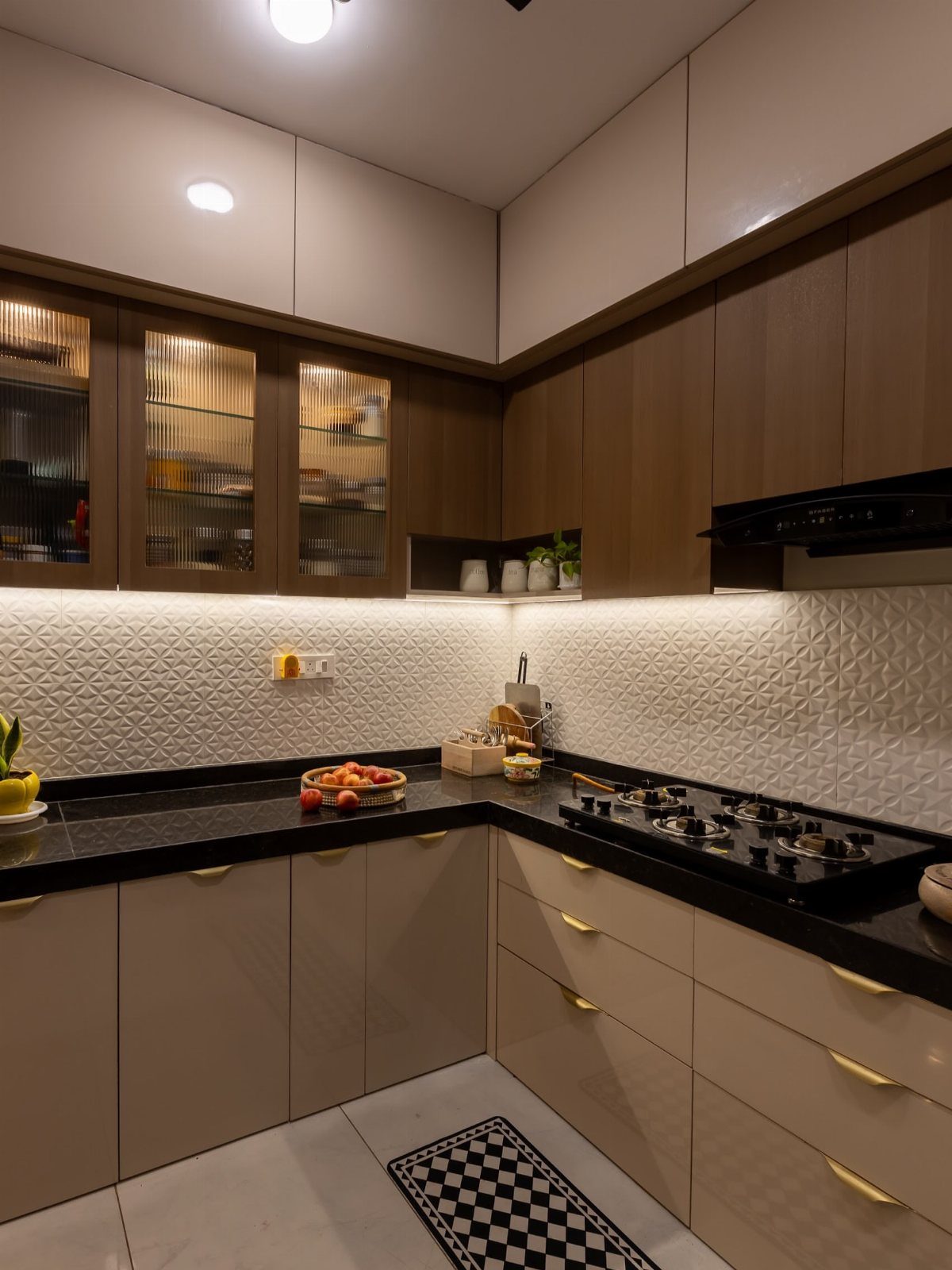 Two tone kitchen cabinets with beige lowers and dark wood uppers and black countertops.