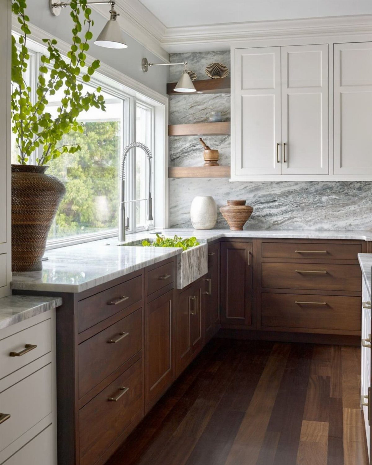 White upper cabinets and dark wood lower cabinets in a bright kitchen setting.