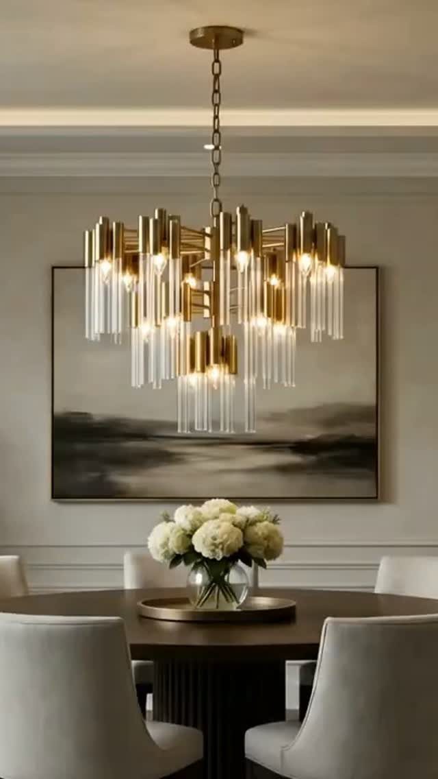 Round walnut dining table with cream chairs and a large gold glass chandelier