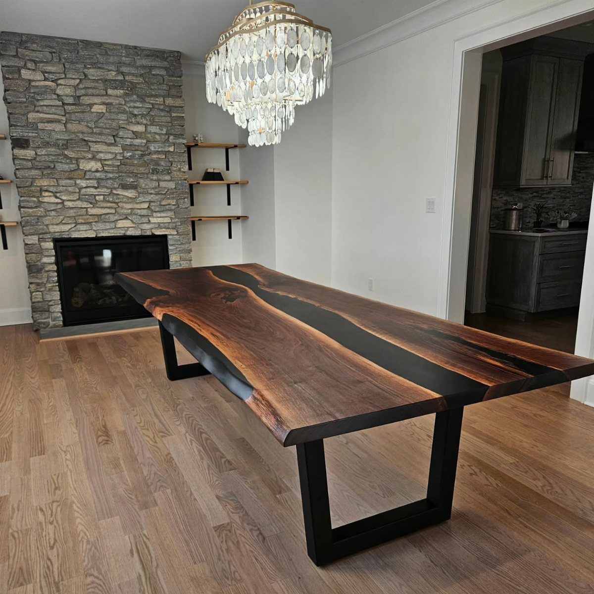 Live-edge walnut dining table with a black resin river inlay and metal legs.